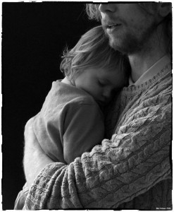 Photo by Mal Holmes.    Molly sleeping in her father's arms  as he conducts his Curator Tour of the new Exhibition in the Open Eye Gallery.